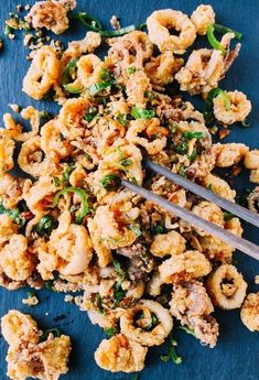 a blue plate topped with fried shrimp and broccoli next to a fork on top of it