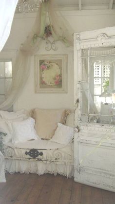 a white room with a couch, mirror and rugs on the wooden flooring