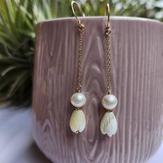 Enhance your  attire with our Pikake Earrings.  The elegant Jasmine floral design and the shimmering Mother of Pearl and South Sea Pearl accents will add a touch of sophistication to any look.  Handmade in Hawaii, these earrings are made with 14K Yellow Gold Fill for a lasting and luxurious finish. Features: Handcarved Mother of Pearl  Jasmine ( Pikake ) flowers Approx. 7mm x 10mm White South sea pearl , approx. 6mm Perfect for tropical vacation, Hawaiian jewelry, birthday gift, anniversary, mothers day, bestfriend, sister, daughter gift. Excellent for wedding, bridal , bridesmaid jewelry. Adjustable White Pearl Earrings For Wedding, Adjustable Teardrop Pearl Earrings For Wedding, White Dangle Earrings For Bridesmaids, Cream Teardrop Earrings For Wedding, White Dangle Bridal Earrings For Bridesmaid, Elegant Mother Of Pearl Flower Earrings, Flower-shaped Mother Of Pearl Jewelry With Pearl Drop, Elegant Mother Of Pearl Flower-shaped Earrings, Elegant Shell-shaped Pearl Earrings In Mother Of Pearl