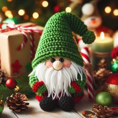 a crocheted christmas gnome sitting on a table next to other ornaments and decorations