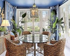 a dining room with blue walls and wicker chairs