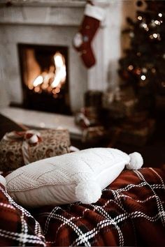 a white pillow sitting on top of a bed next to a fire place