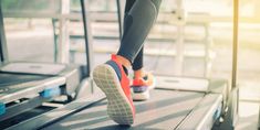 a person walking on a treadmill with their feet in the air and wearing running shoes