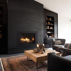 a living room with two couches and a fire place in the middle of it