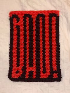 a red and black crocheted square with the word dad written in large letters