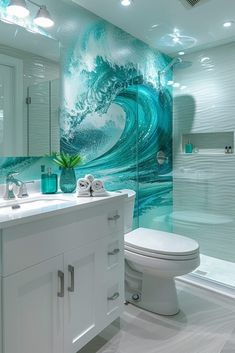 a white toilet sitting next to a bathroom sink under a large glass shower door with waves on it