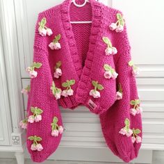 a pink cardigan with flowers on it