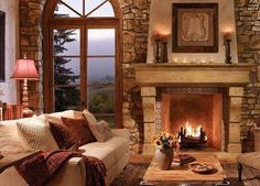 a living room filled with furniture and a fire place in front of a large window