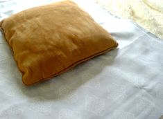 a brown pillow sitting on top of a bed