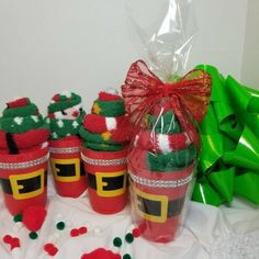 some red cups with green decorations on them and a bag full of candy in the background