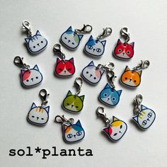 a bunch of keychains with cats on them sitting in the shape of hearts