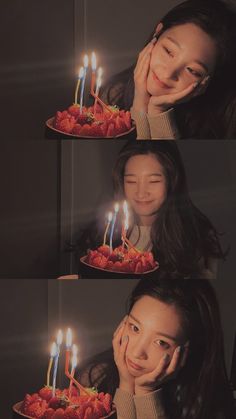 a woman holding a cake with lit candles on it in front of her face and looking at the camera