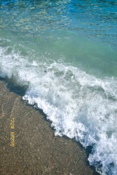 the ocean waves are crashing on the beach