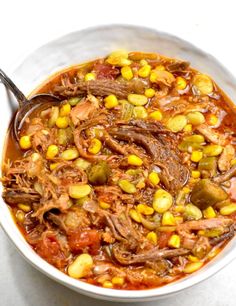 a white bowl filled with meat and corn soup