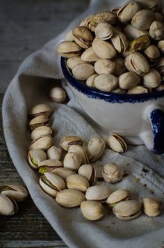 pistachios in a blue and white bowl on a napkin