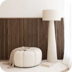 a white ottoman sitting next to a tall lamp