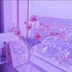 pink flowers in a vase on a window sill overlooking a cityscape and skyscrapers