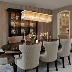 a dining room table and chairs with chandelier in the middle, along with other furniture