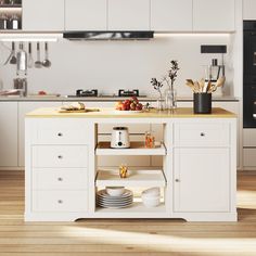 a kitchen island with plates and bowls on it in the middle of a wooden floor