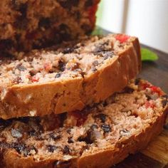 two slices of meatloaf sitting on top of a cutting board next to another piece of bread