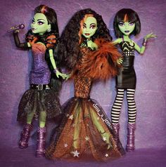 three dolls dressed in halloween costumes standing next to each other on a purple background with black and white stripes