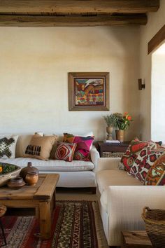 a living room filled with furniture and lots of pillows on top of it's couches