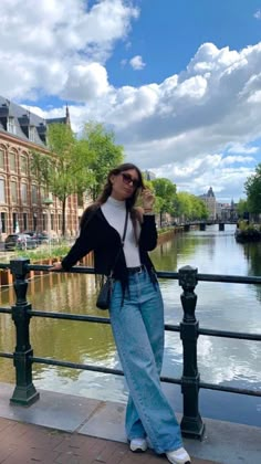 a woman standing on a bridge next to a body of water