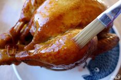 a close up of a chicken on a plate with a brush