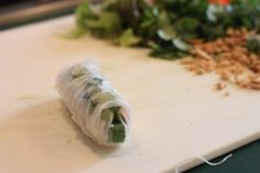 a vegetable wrapped in plastic sitting on top of a cutting board