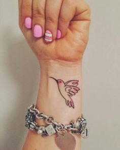 a woman's wrist with a bird and heart tattoo on her left side arm