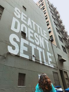 a woman walking past a building with the words seattle doesn't selte on it