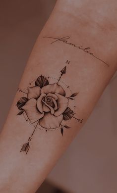 a rose tattoo on the arm with an arrow and name written in cursive writing