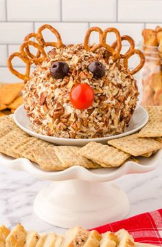 a cake made to look like a mouse with pretzels on it and some crackers