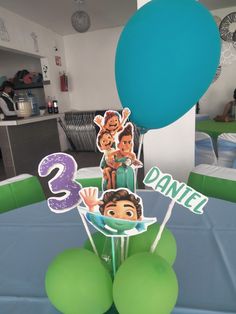 a birthday cake with balloons and decorations on the table in front of it is an image of three people