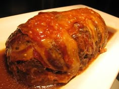 a meatloaf covered in sauce on a white plate