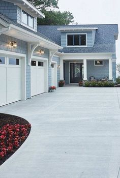 a house with two garages and flowers in the front yard