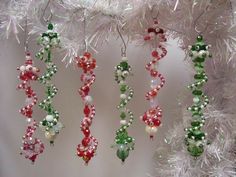 christmas ornaments hanging from a white tree in the shape of beads and pearls, on display