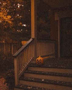 a halloween pumpkin sitting on the steps of a house