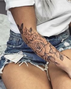 a woman's arm with flowers on it and the bottom half of her leg