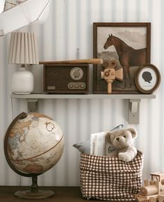 a teddy bear is sitting on a chair in front of a wall with striped walls