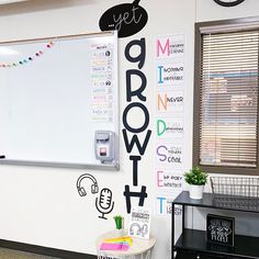 a white board with writing on it in a classroom area next to a black and white desk