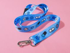 This adorable blue pill lanyard is perfect to match your Menhera Kei outfit when you go to conventions or fashion events! It's cute pill design also makes it a fun gift for spoonies, nurses, doctors, and fans of Japanese alternative fashion. The lanyard has a plastic clasp at the back (this is not quick release, because my manufacturer made a mistake in production). It has a sewn end and a metal clasp for adding an ID card, event pass, and/or fun keyrings. The lanyard measures 50cm from back fastening to end of metal clasp. Blue Lanyard With Key Leash For Personal Use, Blue Lanyard With Key Leash For Gift, Blue Lanyard With Key Leash As Gift, Blue Lanyards With Key Leash As Gift, Pill Design, Japanese Alternative Fashion, Menhera Kei, Blue Pill, Fashion Events