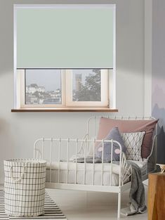 a white bed sitting under a window in a bedroom