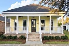 a yellow house with white columns and pillars