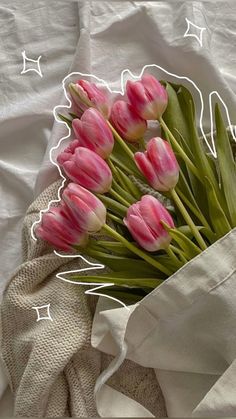 a bouquet of pink tulips sitting on top of a white sheet