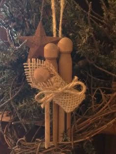 an ornament hanging from a christmas tree with two wooden pegs attached to it