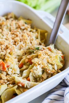 a casserole dish with pasta and vegetables in it on a blue and white towel