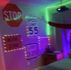 a bedroom with neon lights and signs on the wall