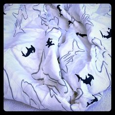 a white blanket with black cats on it