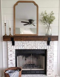 a fireplace with a mirror above it and a basket in front of the fire place